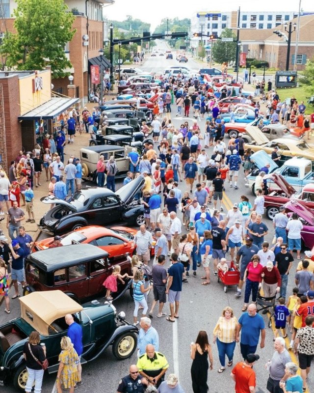 Large street crowd among classic cars on a downtown Kirkwood street during the Route 66 festival