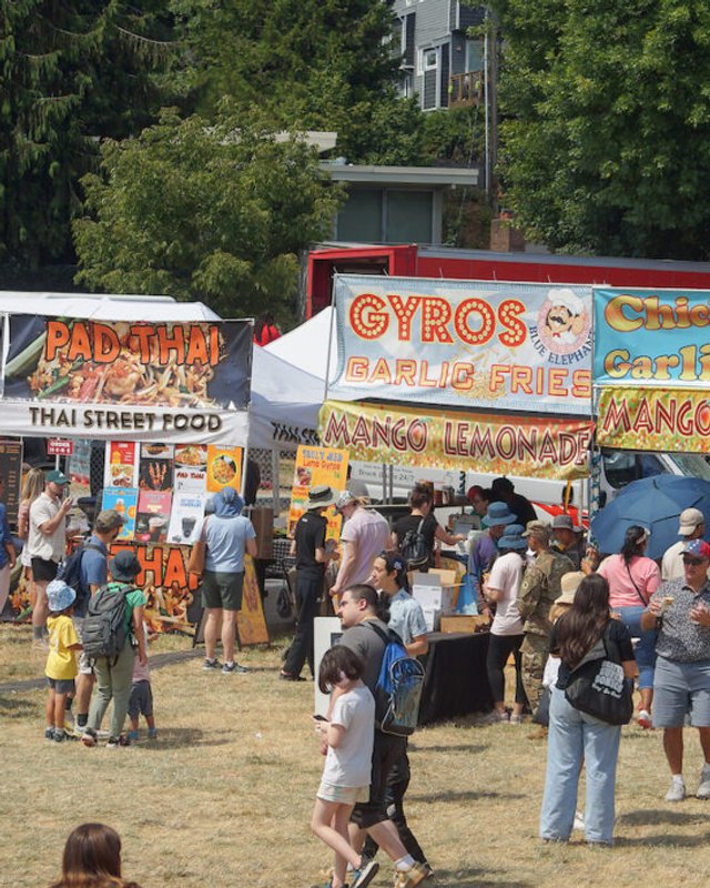Crowd of visitors walking past food booths and vendor tents at Seafair Weekend Festival