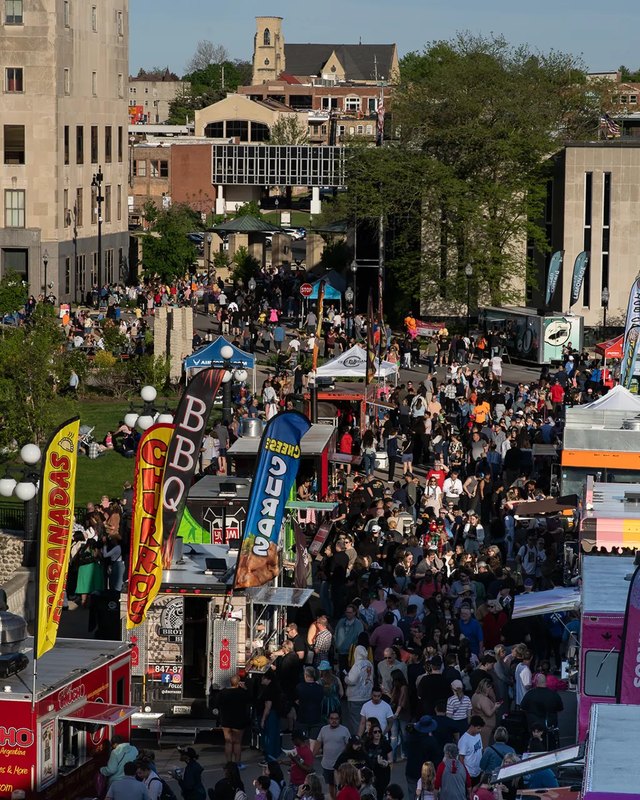 Large crowd and food trucks filling a downtown Aurora street during the city's food truck festival.