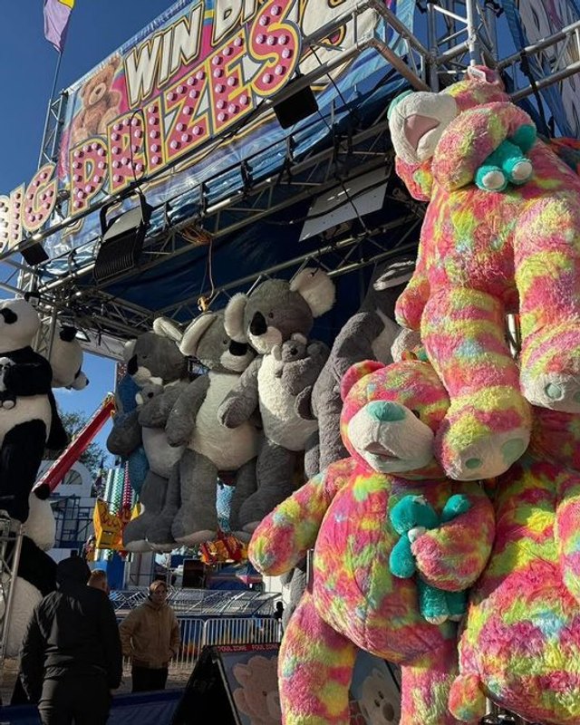 Stacked plush prizes and carnival game stalls at the Charlotte County Fair