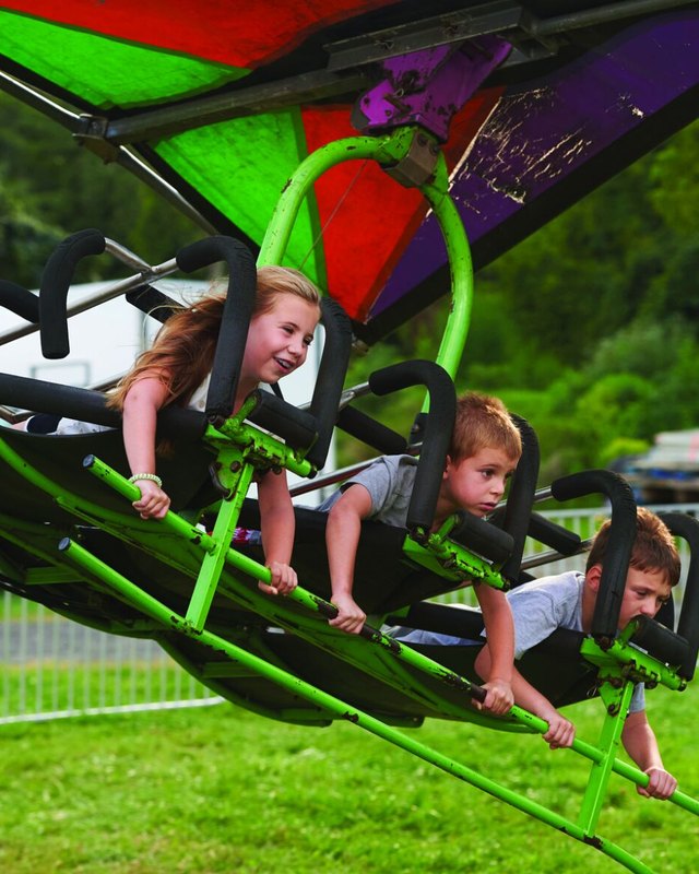 Children riding a green and purple amusement ride at the Middletown Grange Fair