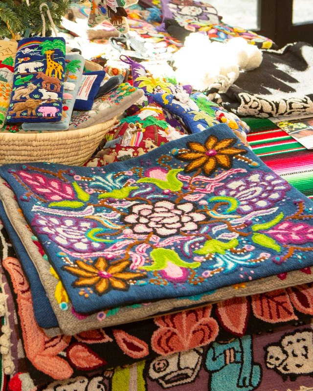 Colorful embroidered textiles and woven goods displayed on a market table