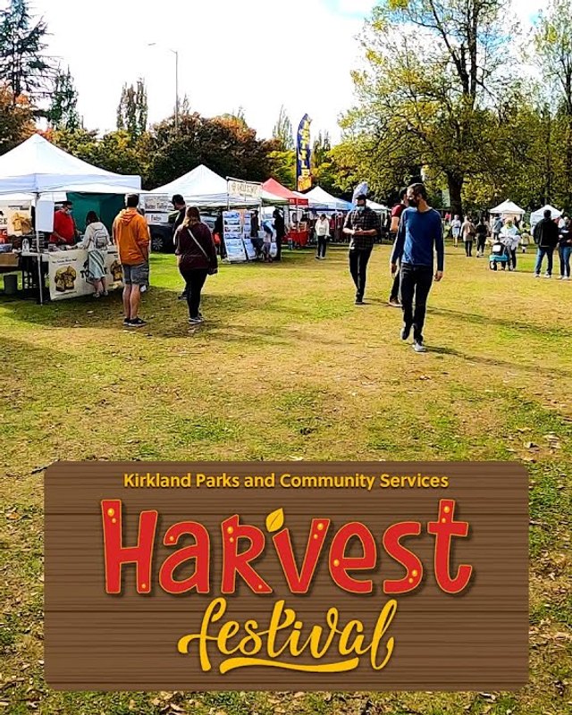 Shoppers and white vendor tents on a grassy lawn at the Kirkland Harvest Festival