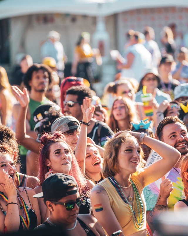 Crowd of festival-goers dancing and cheering at Kentuckiana Pride