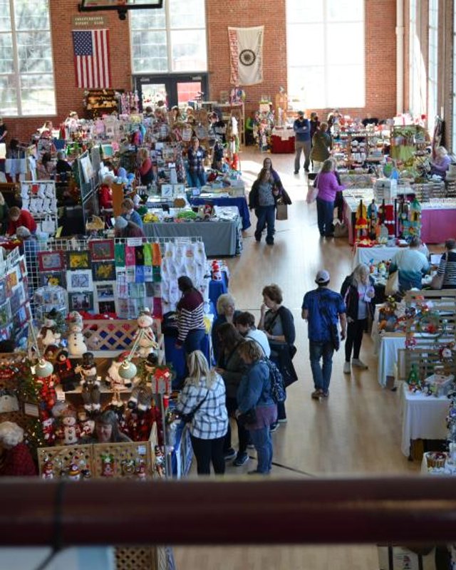 Vendors and shoppers browse holiday crafts and goods on the floor of the Sermon Center during the Best Little Arts and Crafts Show.