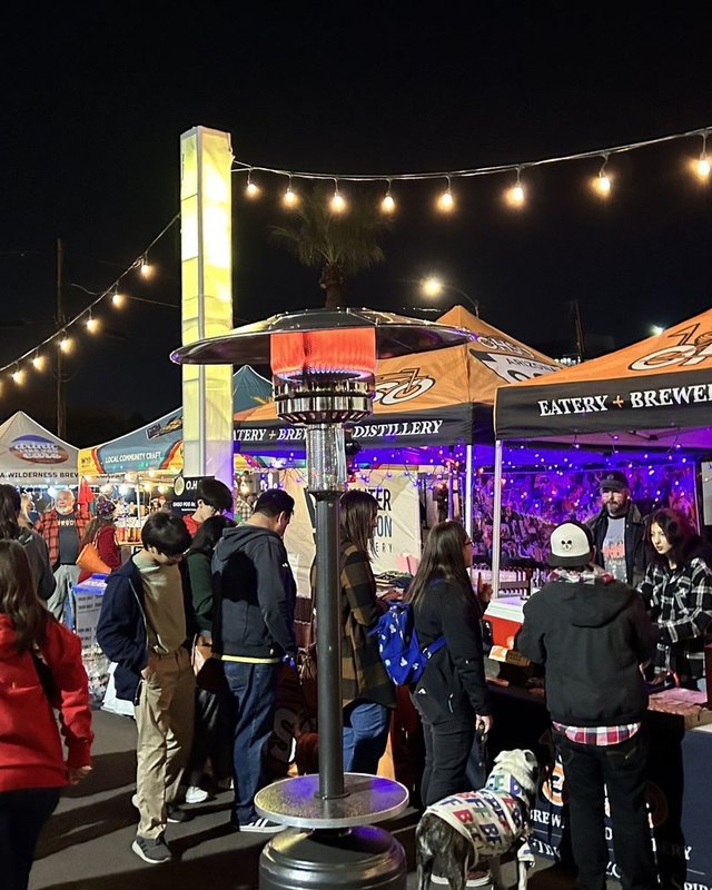 Night market crowd browsing tents and booths under string lights in Old Town Scottsdale.
