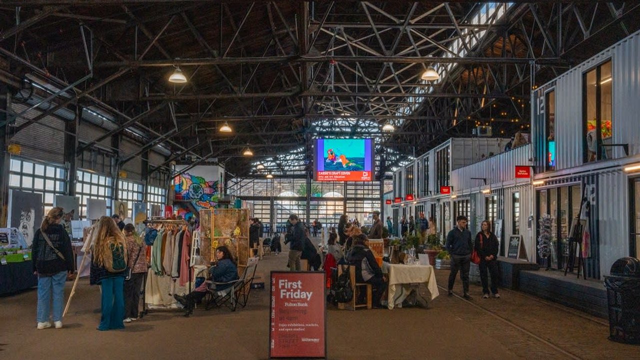 Shoppers and vendor stalls at the First Friday market inside Cherry Street Pier.