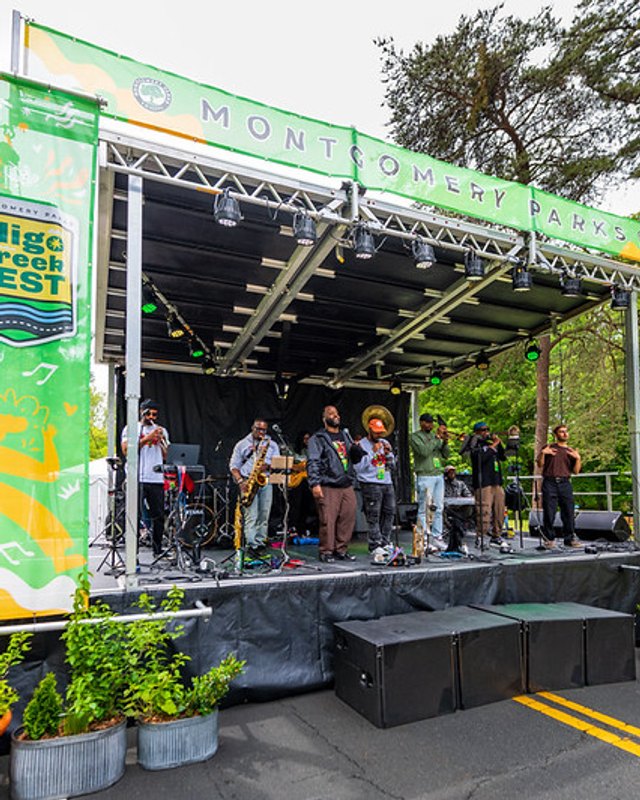Band plays on the main stage under green Sligo Creek Fest banners at the festival.