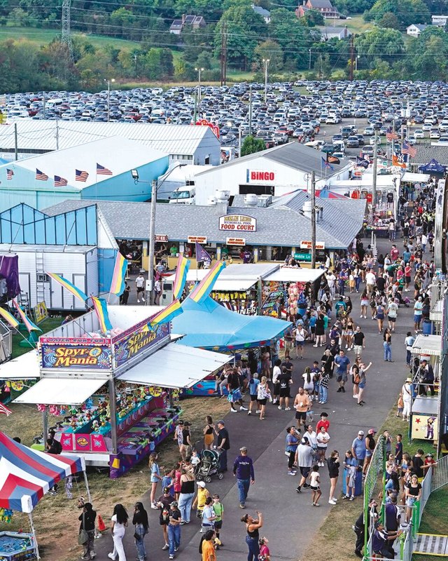 Aerial view of crowds walking between rides and tents at the Berlin Fair grounds.