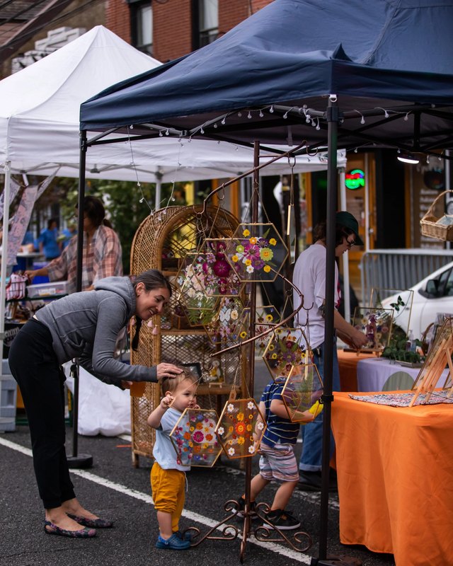 Shoppers and a vendor tent with crafts on display at the Northern Liberties street market