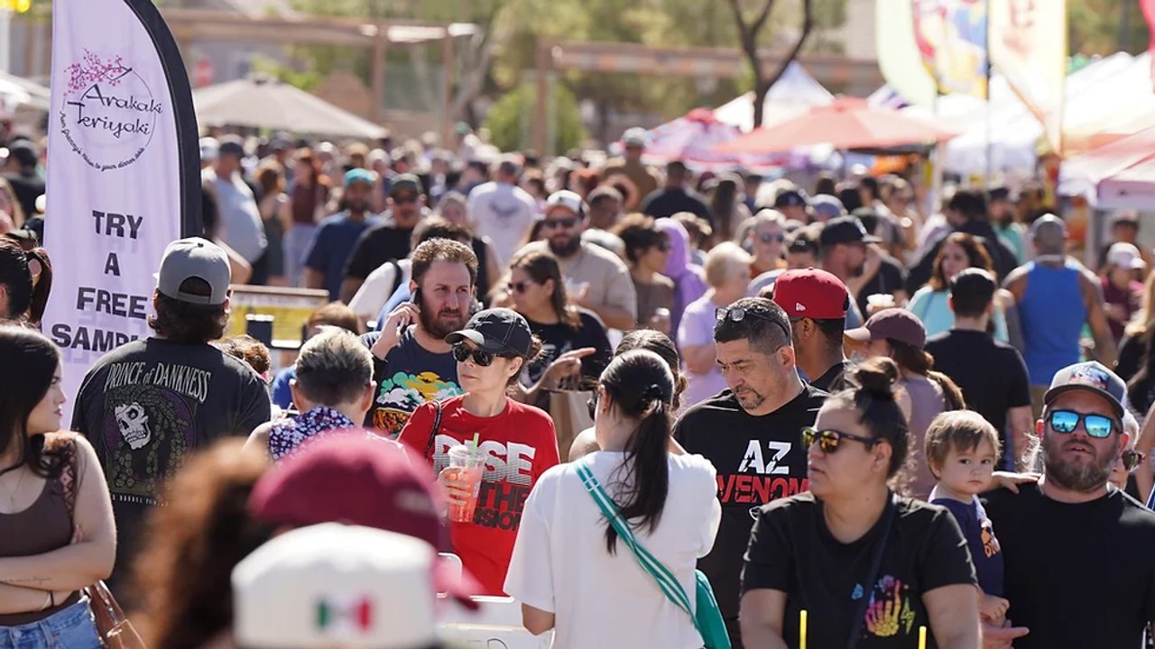 Large crowd of shoppers among market tents at the Desert West event.