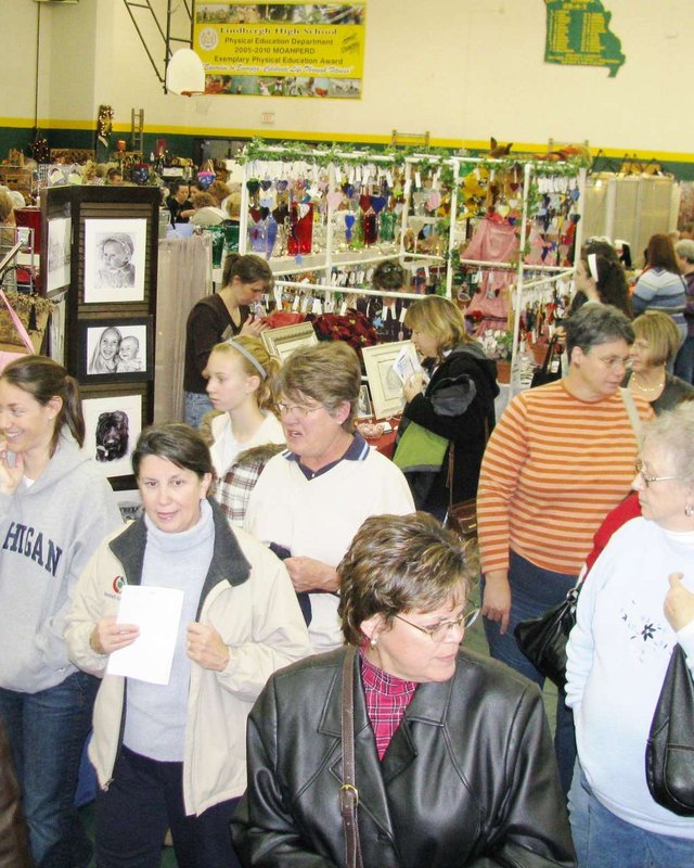 Crowd of shoppers browsing crafter booths at an indoor arts and crafts fair