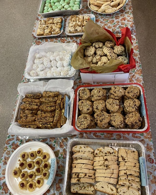 Trays of homemade cookies, fudge and baked goods laid out on a table for the parish holiday fair cookie walk.