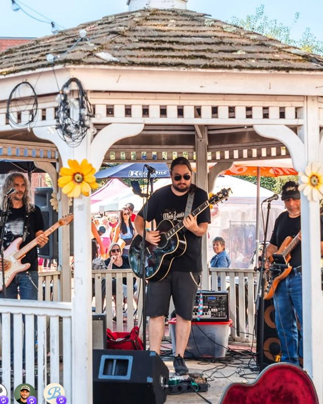 Live band performing under a gazebo decorated with flowers at an outdoor Porchfest event.