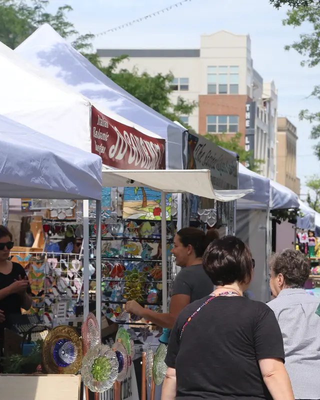 Shoppers browsing booths under white tents at a street festival in Collingswood.