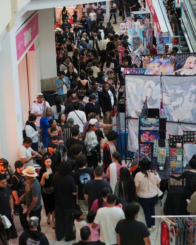 Dense crowd of attendees browsing anime art booths at Anime Night Mart