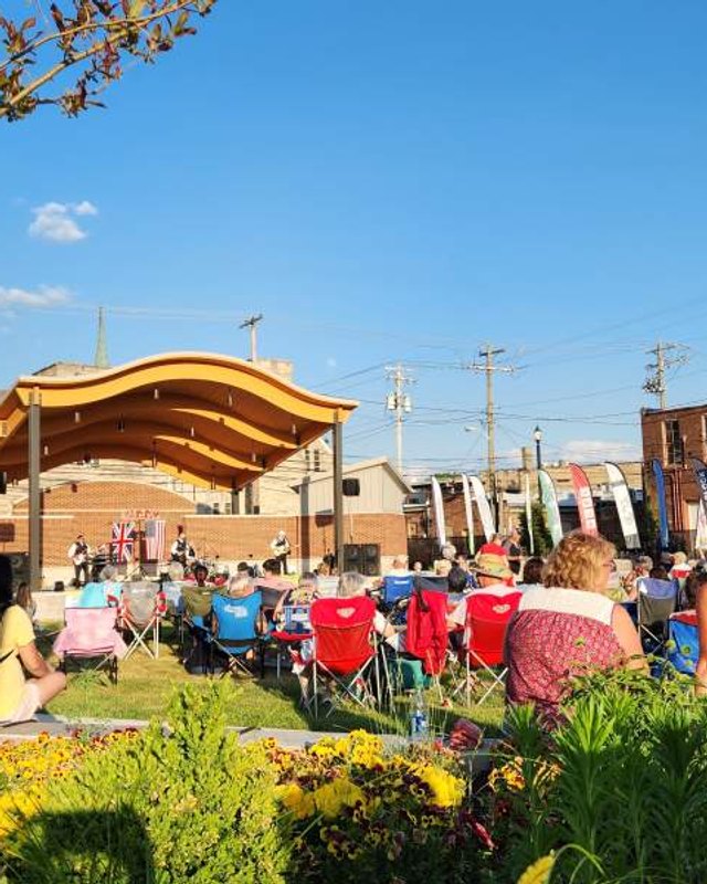 Outdoor summer concert crowd seated in lawn chairs before a bandshell in downtown Martinsville.