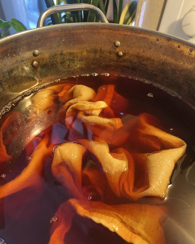 Fabric simmering in a copper dye pot during a natural dyes demonstration