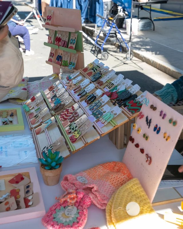 Handmade jewelry, cards and crafts laid out on a craft booth table at the festival