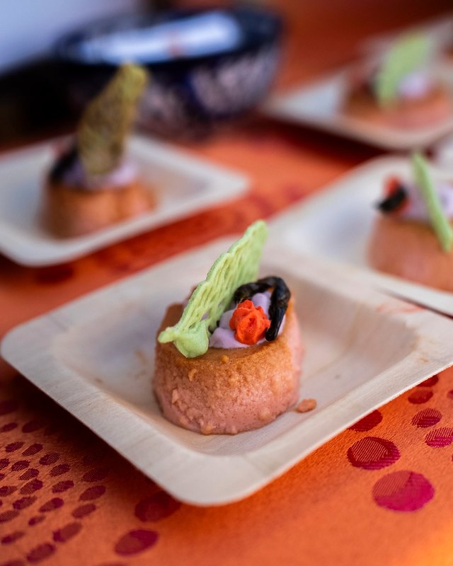 Bite-sized appetizers with garnish served on white plates at the Devour Culinary Classic.