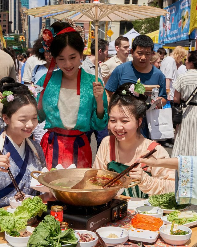 Festival shoppers and costumed guests gathered around a food stall at a Panda Fest market.