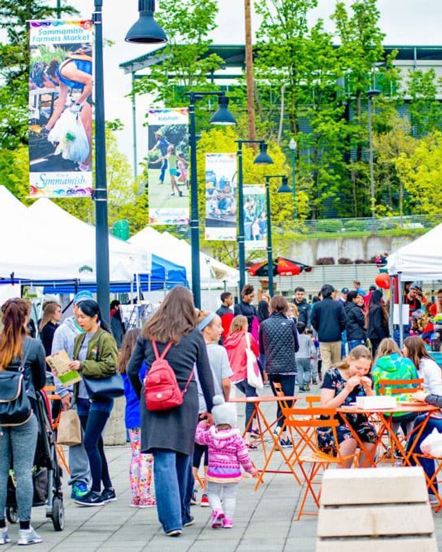 Shoppers and vendor tents at the Sammamish Farmers Market on the Sammamish Commons plaza.