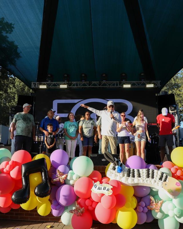 Stage with a crowd and colorful balloon arch at the BloomFest festival in Duncanville