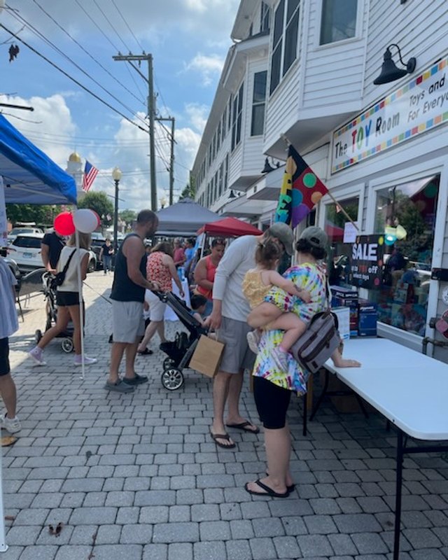 Shoppers and vendor tents lining a Bethel street during the Summer Shop and Stroll