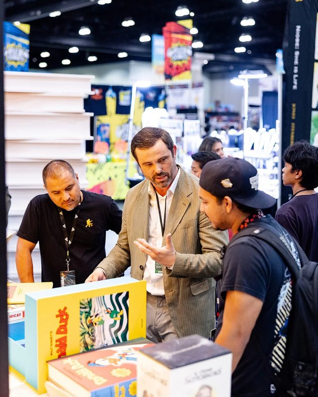 Shoppers and staff browsing a booth with colorful merchandise at L.A. Comic Con