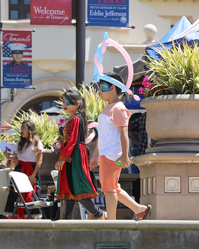 Shoppers and performers walking past vendor tents in Old Town Temecula during CultureFest