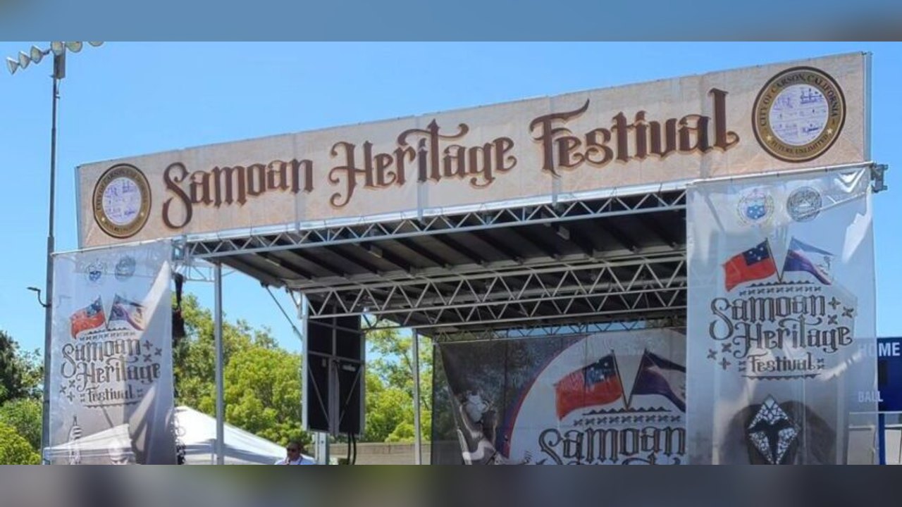 Stage with a Samoan Heritage Festival banner and side banners under a blue sky.