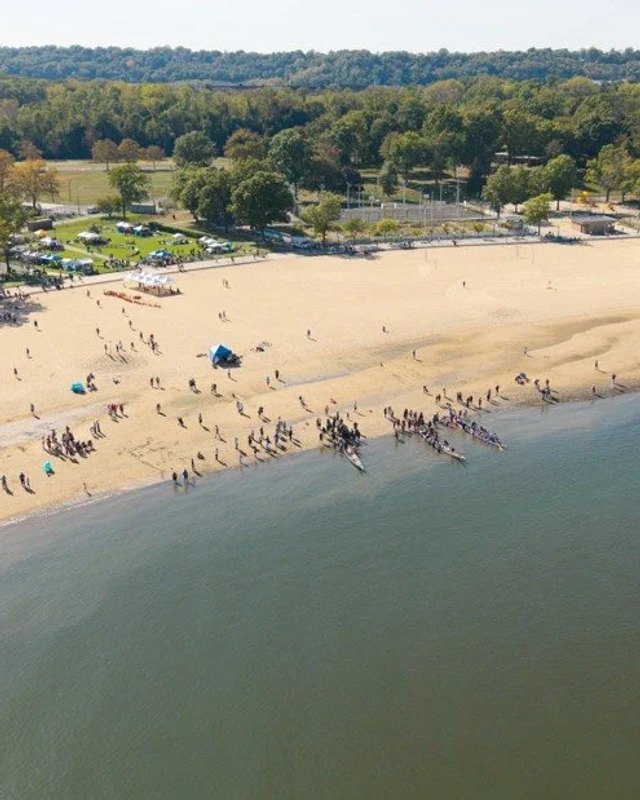 Aerial view of a sandy beach with people and small boats at the water's edge, Port Washington, NY.