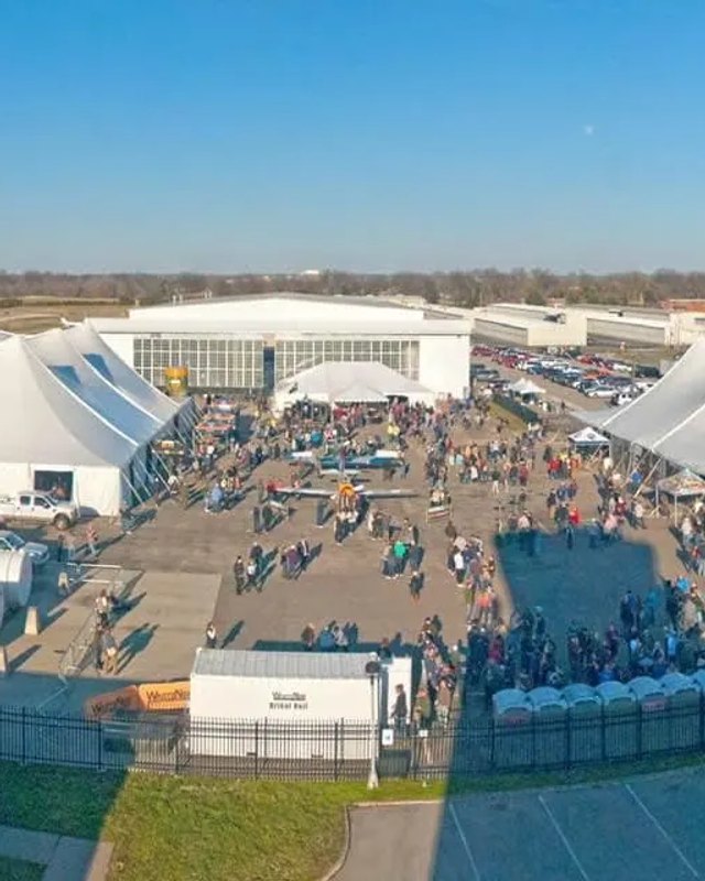 Aerial view of large white event tents and a crowd at the Tailspin Ale Fest venue