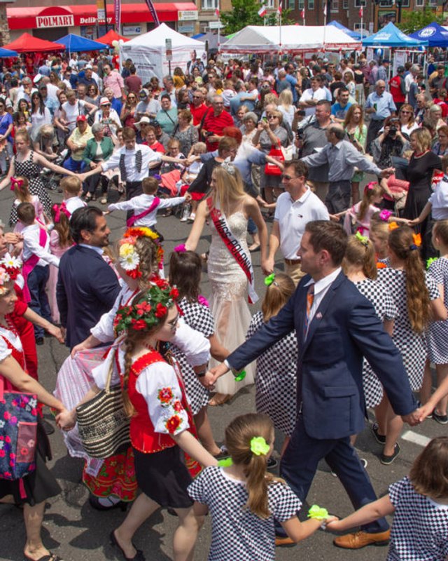 Costumed dancers and a crowd on a street during the Little Poland festival in New Britain.