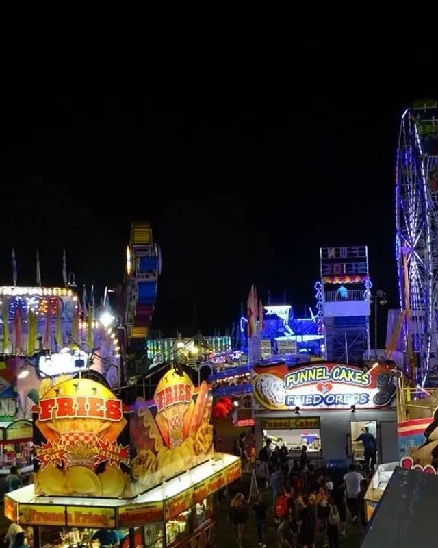 Night view of the Southampton Days fair rides, lit up with a Ferris wheel and food stands.