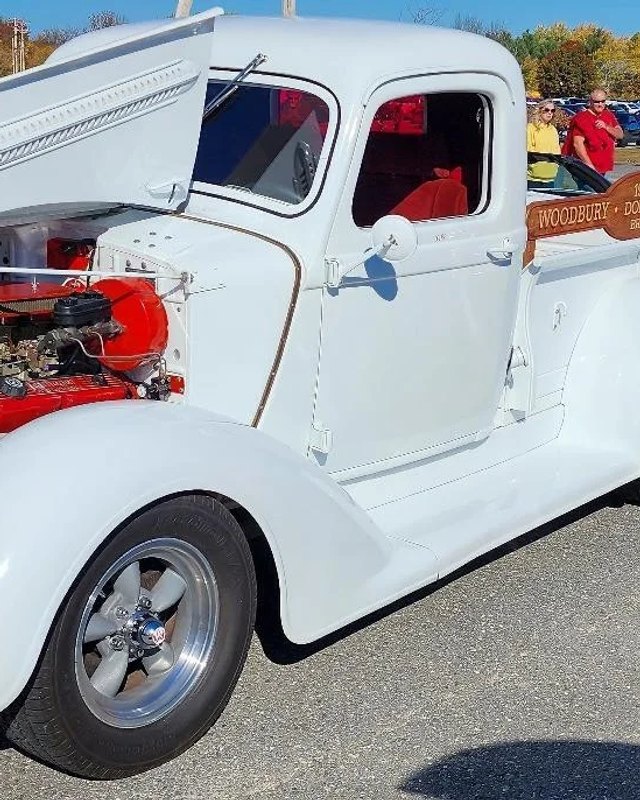 White vintage pickup truck with open hood on display at the Hot Rods & Heroes car show