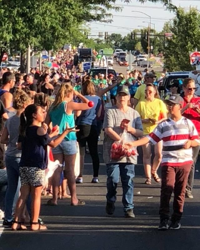 Crowd of spectators and families walking along a street at the Meridian Dairy Days event.