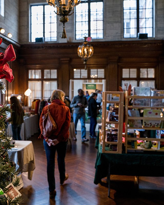 Shoppers browsing booths in the Mansion at Strathmore hall beside a decorated holiday tree