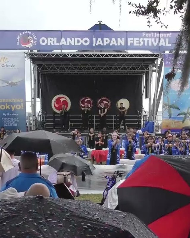 Crowd under umbrellas facing the Orlando Japan Festival stage at Kissimmee Lakefront Park