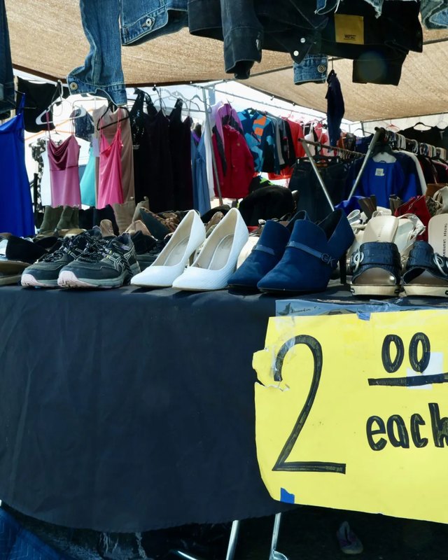 Clothing and shoes priced at 2 dollars each on tables at the San Joaquin County Fairgrounds flea market.