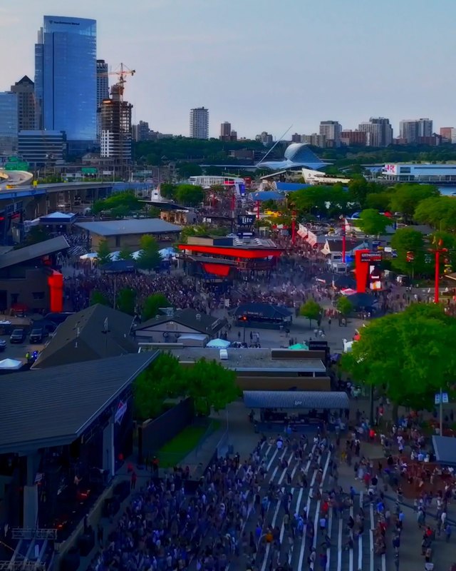 Aerial view of the Summerfest grounds with a large crowd along the lakefront and city skyline behind
